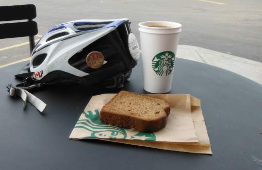 Starbucks americano and slice of banana bread. Note the official coffeeneuring pin on my helmet!