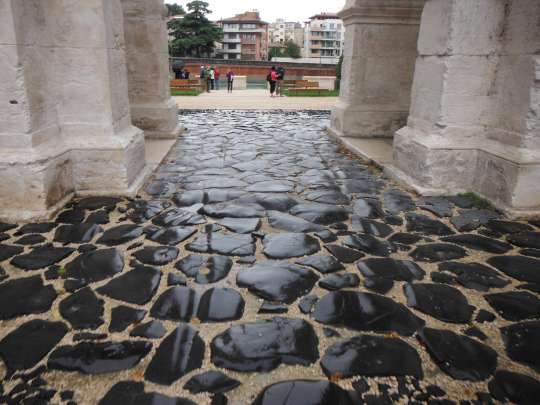 The original basalt paving stones under the Gavi Arch, worn down by centuries of wagon wheels.